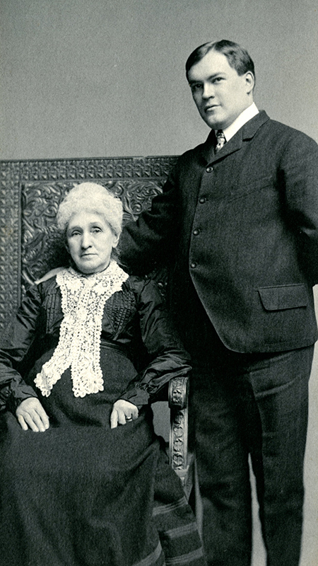 Cabell standing with grandmother who is seated in an elaborate chair